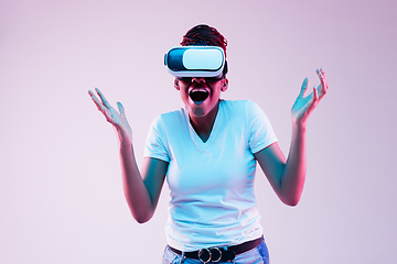 Image showing Young african-american woman\'s using VR-glasses in neon light