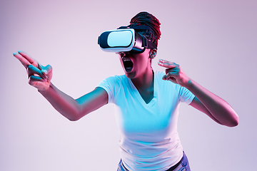 Image showing Young african-american woman\'s using VR-glasses in neon light