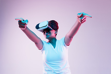 Image showing Young african-american woman\'s using VR-glasses in neon light