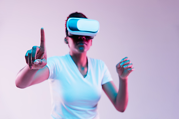 Image showing Young african-american woman\'s using VR-glasses in neon light