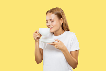 Image showing Caucasian young woman\'s half-length portrait on yellow background