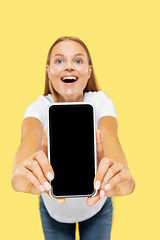 Image showing Caucasian young woman\'s half-length portrait on yellow background