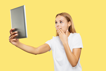 Image showing Caucasian young woman\'s half-length portrait on yellow background