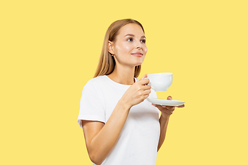 Image showing Caucasian young woman\'s half-length portrait on yellow background