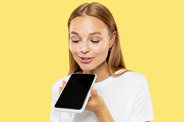 Image showing Caucasian young woman\'s half-length portrait on yellow background