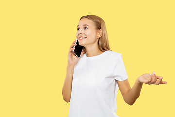 Image showing Caucasian young woman\'s half-length portrait on yellow background