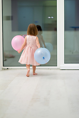 Image showing cute little girl playing with balloons