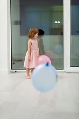 Image showing cute little girl playing with balloons