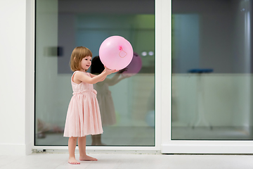 Image showing cute little girl playing with balloons