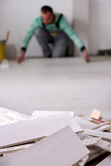 Image showing worker installing the ceramic wood effect tiles on the floor