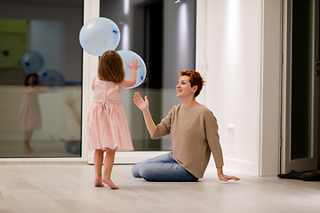 Image showing mother and cute little daughter playing with balloons