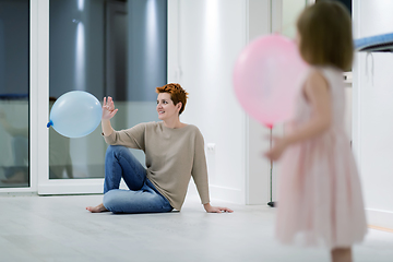 Image showing mother and cute little daughter playing with balloons