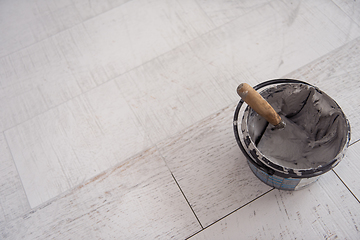 Image showing Ceramic wood effect tiles and tools for tiler on the floor