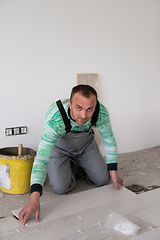 Image showing worker installing the ceramic wood effect tiles on the floor