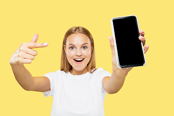 Image showing Caucasian young woman\'s half-length portrait on yellow background