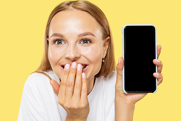 Image showing Caucasian young woman\'s half-length portrait on yellow background