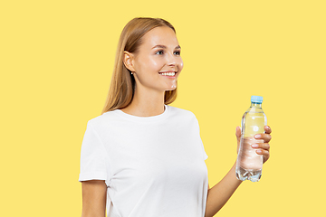 Image showing Caucasian young woman\'s half-length portrait on yellow background