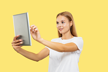 Image showing Caucasian young woman\'s half-length portrait on yellow background