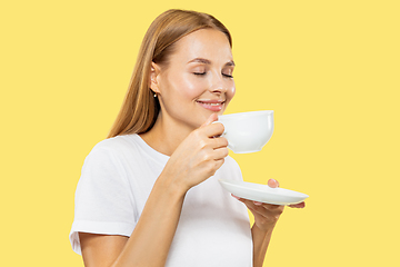 Image showing Caucasian young woman\'s half-length portrait on yellow background