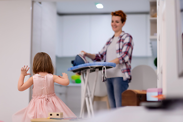 Image showing mother and little daughter spending time together at home