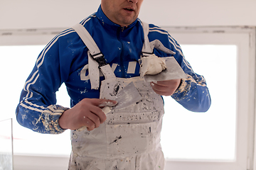 Image showing construction worker plastering on gypsum walls