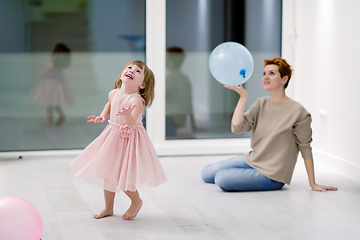 Image showing mother and cute little daughter playing with balloons