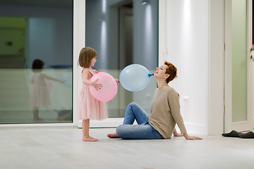 Image showing mother and cute little daughter playing with balloons