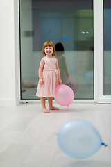 Image showing cute little girl playing with balloons