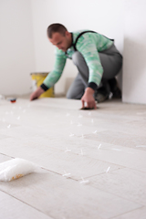 Image showing worker installing the ceramic wood effect tiles on the floor