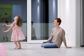 Image showing mother and cute little daughter playing with balloons