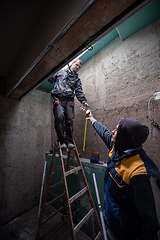 Image showing construction workers installing roof window