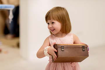 Image showing little girl enjoying while playing with mother\'s jewelry