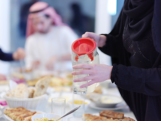 Image showing Muslim family having Iftar dinner drinking water to break feast