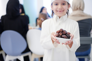 Image showing little muslim boy holding a plate full of sweet dates