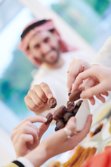 Image showing Muslim family having Iftar dinner eating dates to break feast