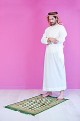 Image showing young arabian muslim man praying on the floor at home