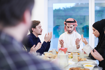 Image showing traditional muslim family praying before iftar dinner