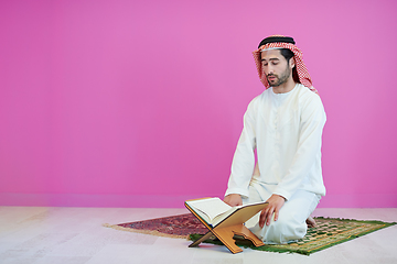 Image showing young arabian muslim man reading Quran at home