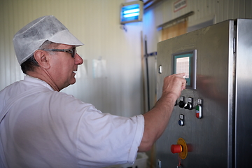 Image showing Cheese production cheesemaker working in factory