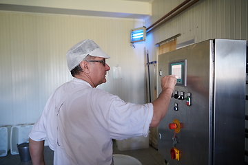 Image showing Cheese production cheesemaker working in factory