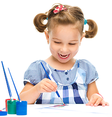 Image showing Little girl is painting with gouache