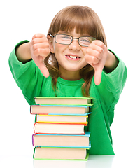 Image showing Little girl is reading a book