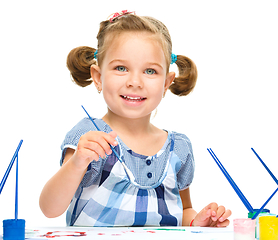 Image showing Little girl is painting with gouache