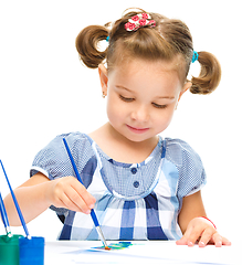 Image showing Little girl is painting with gouache