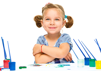 Image showing Little girl is painting with gouache