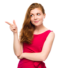 Image showing Portrait of a young woman pointing to the left