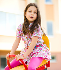 Image showing Young happy girl is swinging in playground