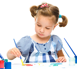 Image showing Little girl is painting with gouache