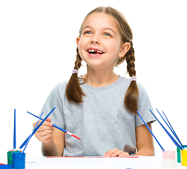 Image showing Little girl is painting with gouache