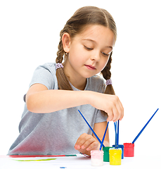 Image showing Little girl is painting with gouache